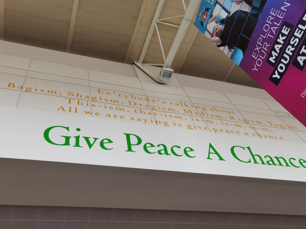 Beatles 'Give Peace a Chance' Lyrics painted on the wall.